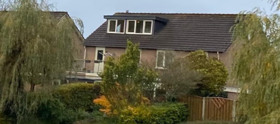 een dakkapel vanaf een afstand met het hele huis in zicht 