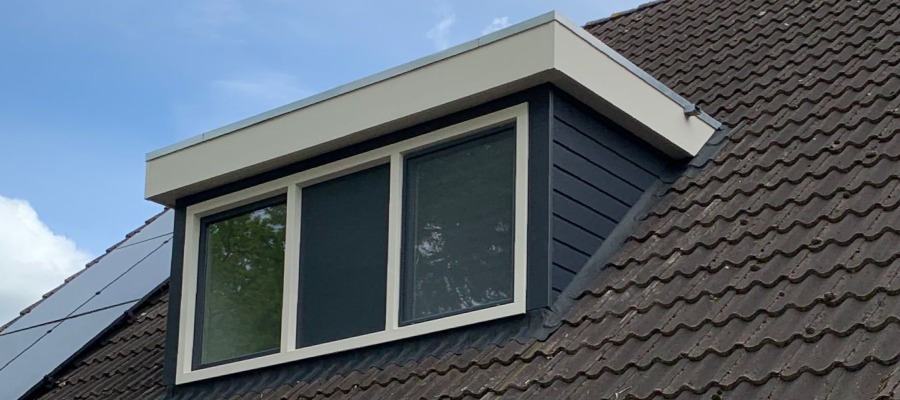 Kunststof dakkapel op een woning met links een rij zonnepanelen.